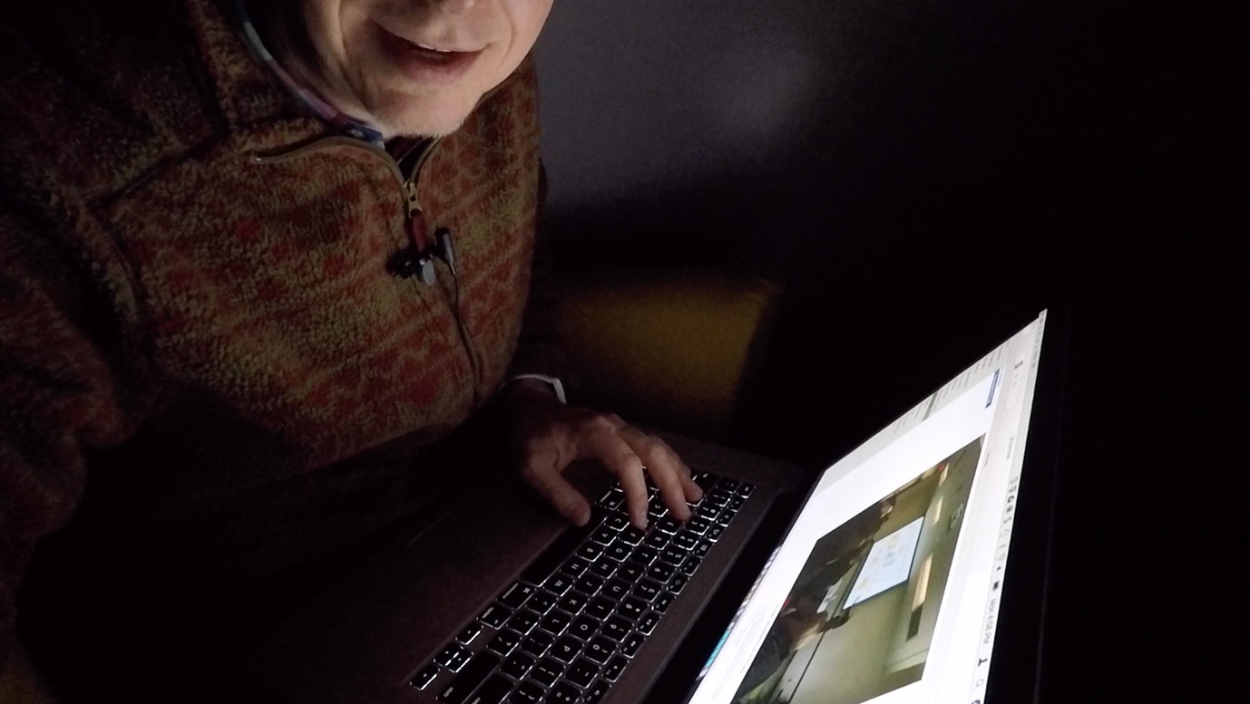 Dennis Cheatham in the dark working on a computer.