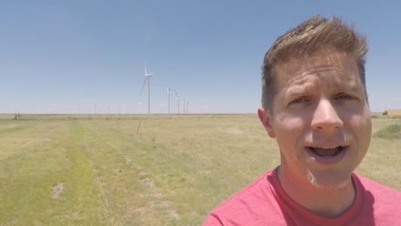Dennis Cheatham in front of wind turbines on the plains of Texas