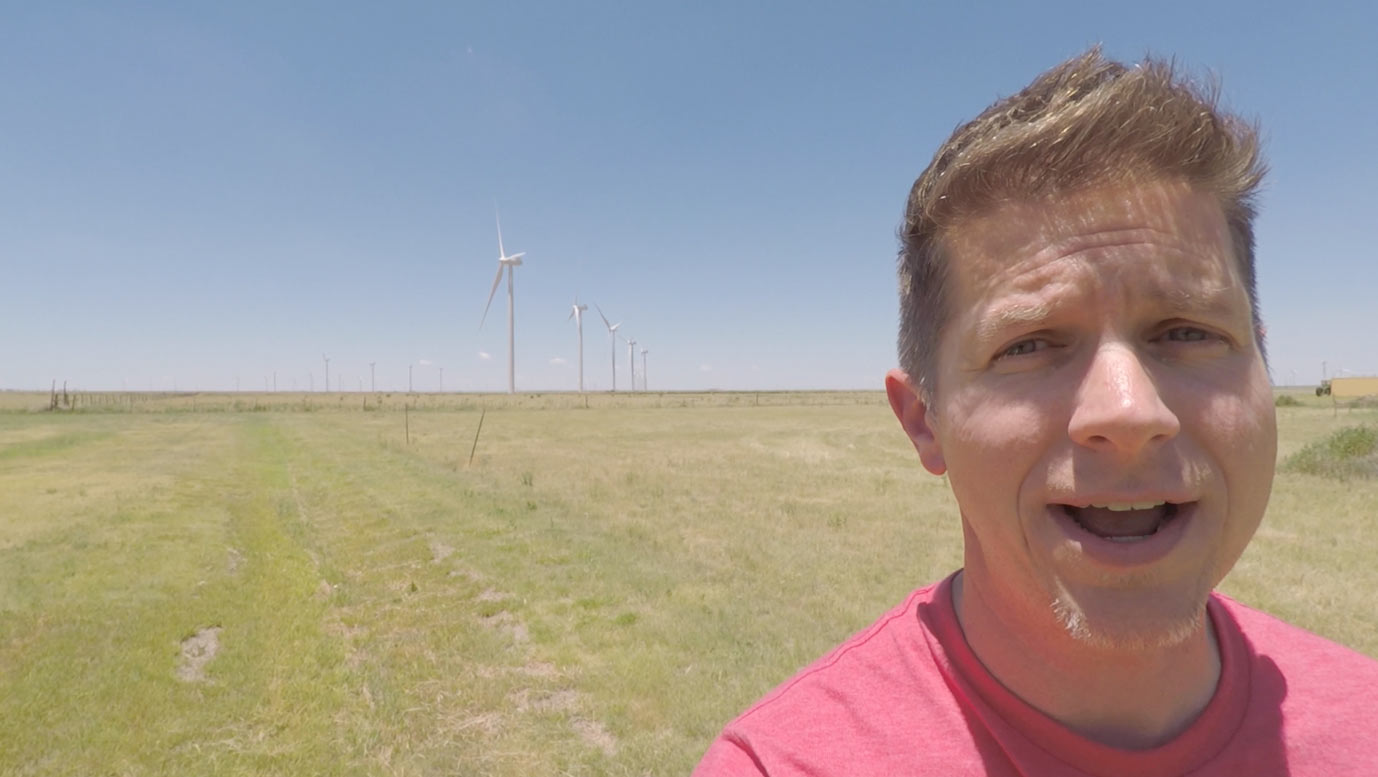 Dennis Cheatham in front of wind turbines on the plains of Texas