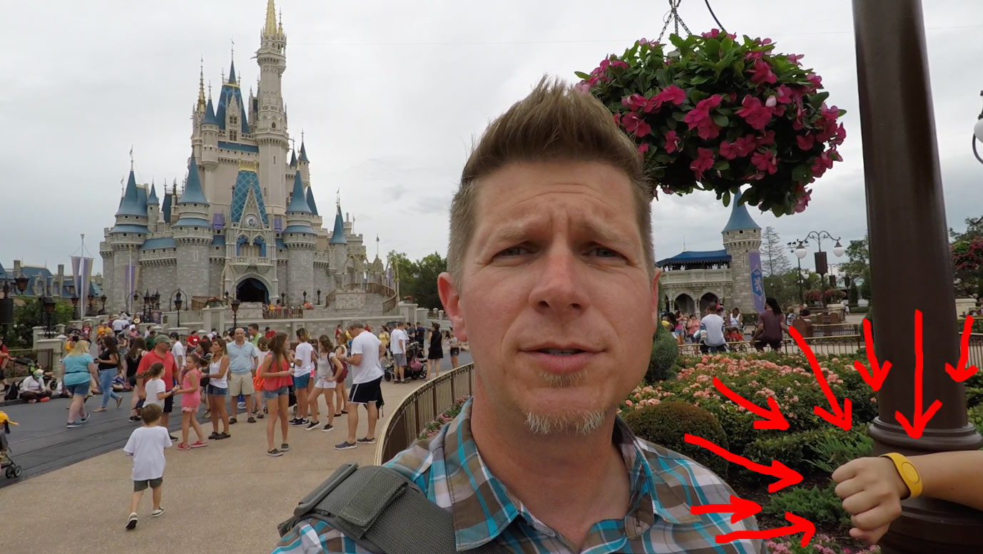 Dennis Cheatham speaking with his son's arm in the background, arrows pointing to it, at Disney